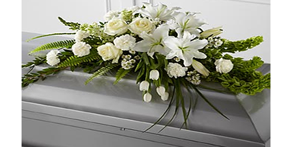 Casket with white flower arrangement on top